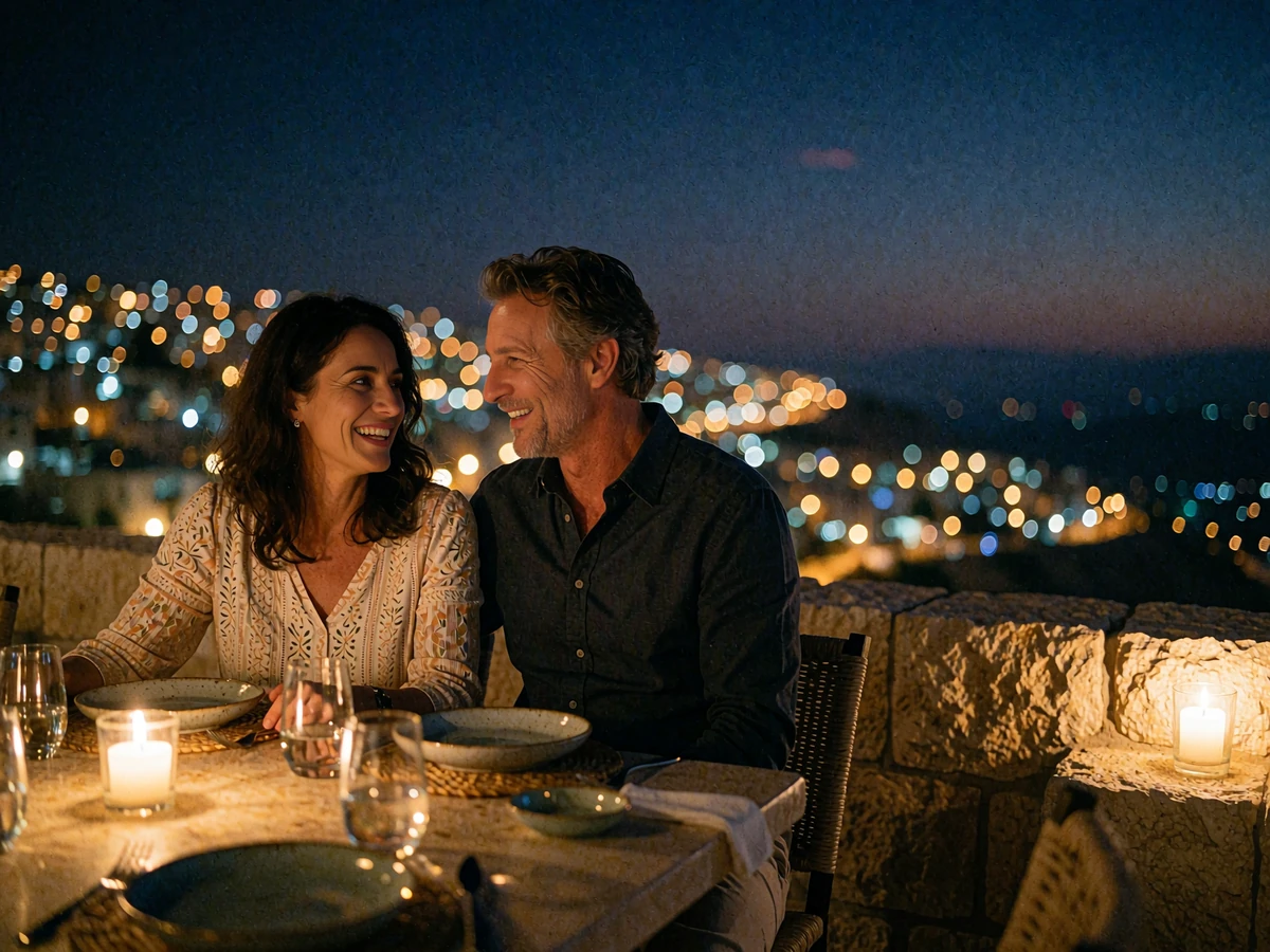 Couple laughing together at a candlelit table on a restaurant terrace overlooking Amman at night